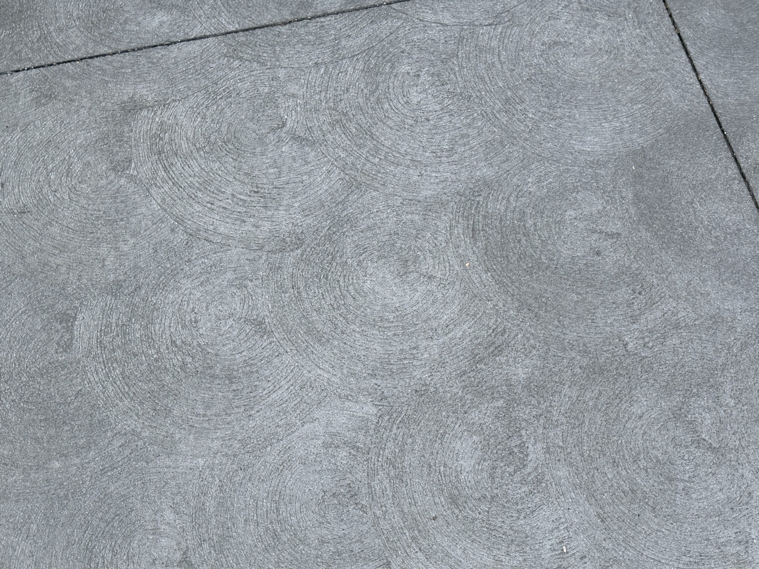 The new pavement has a subtle swirl pattern. It does look better than the splotchy pavement of late 2025.