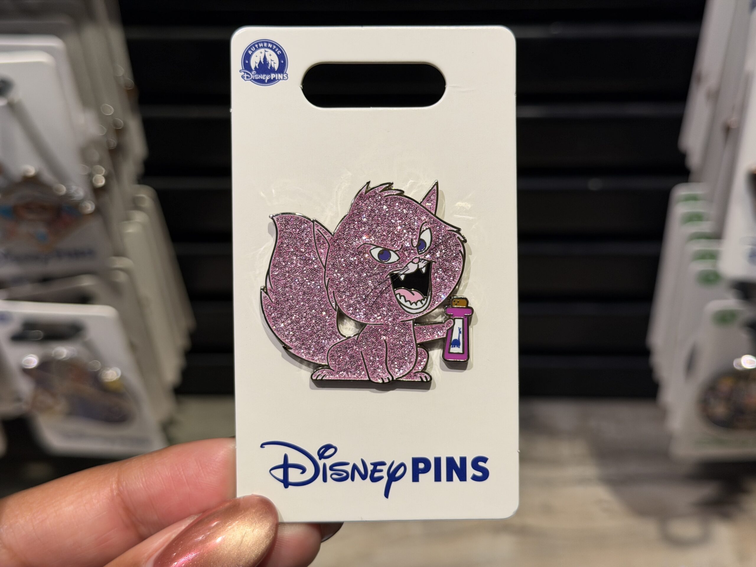 This Yzma pin is a similar glittery style. It depicts her as a cat holding the llama potion.