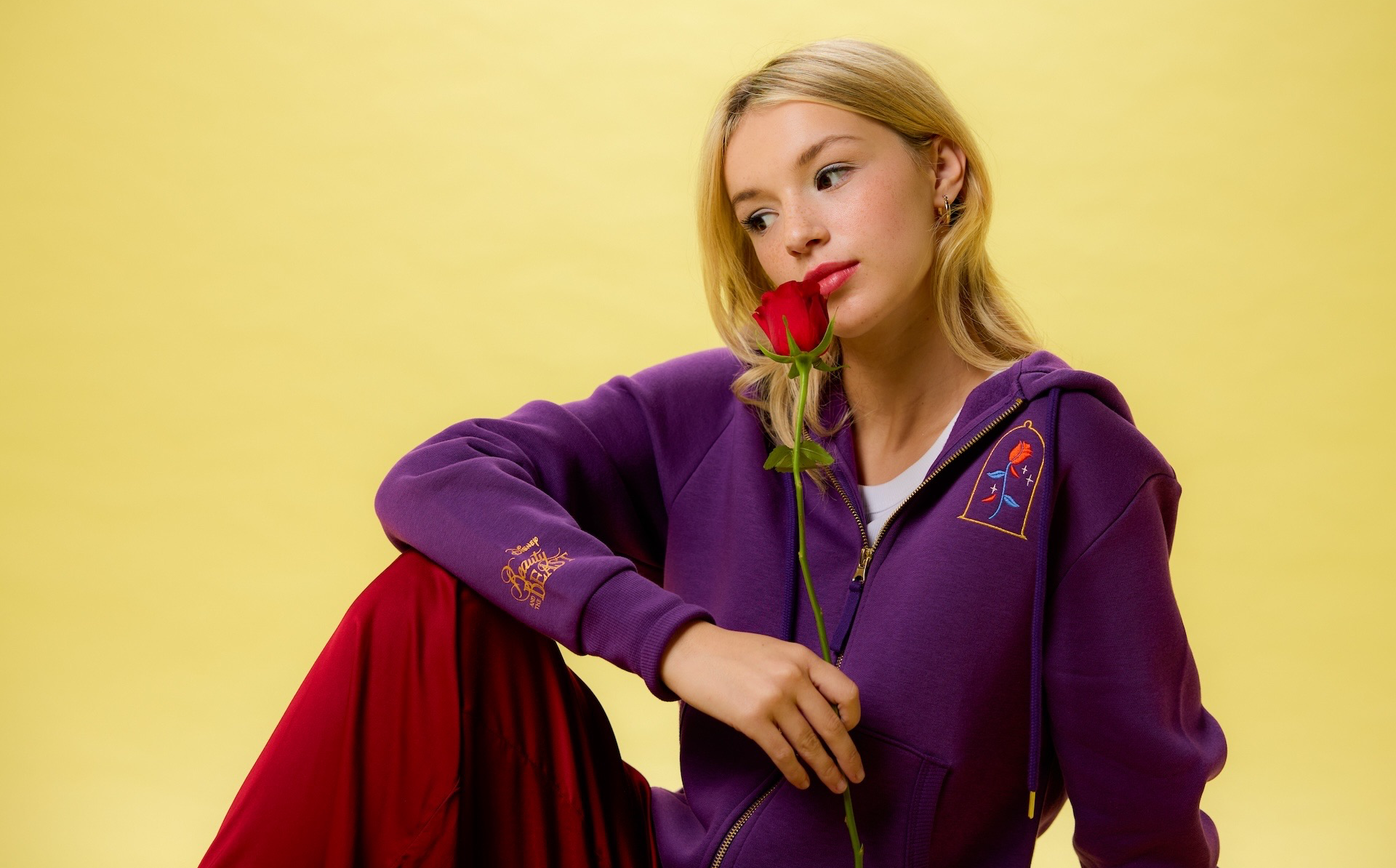 This rich purple Zip Hoodie for Women has lots of little details, like the shimmering film logo on the sleeve, embroidered rose on the front, and picturesque portrait of Belle and the bewitched prince on the back.