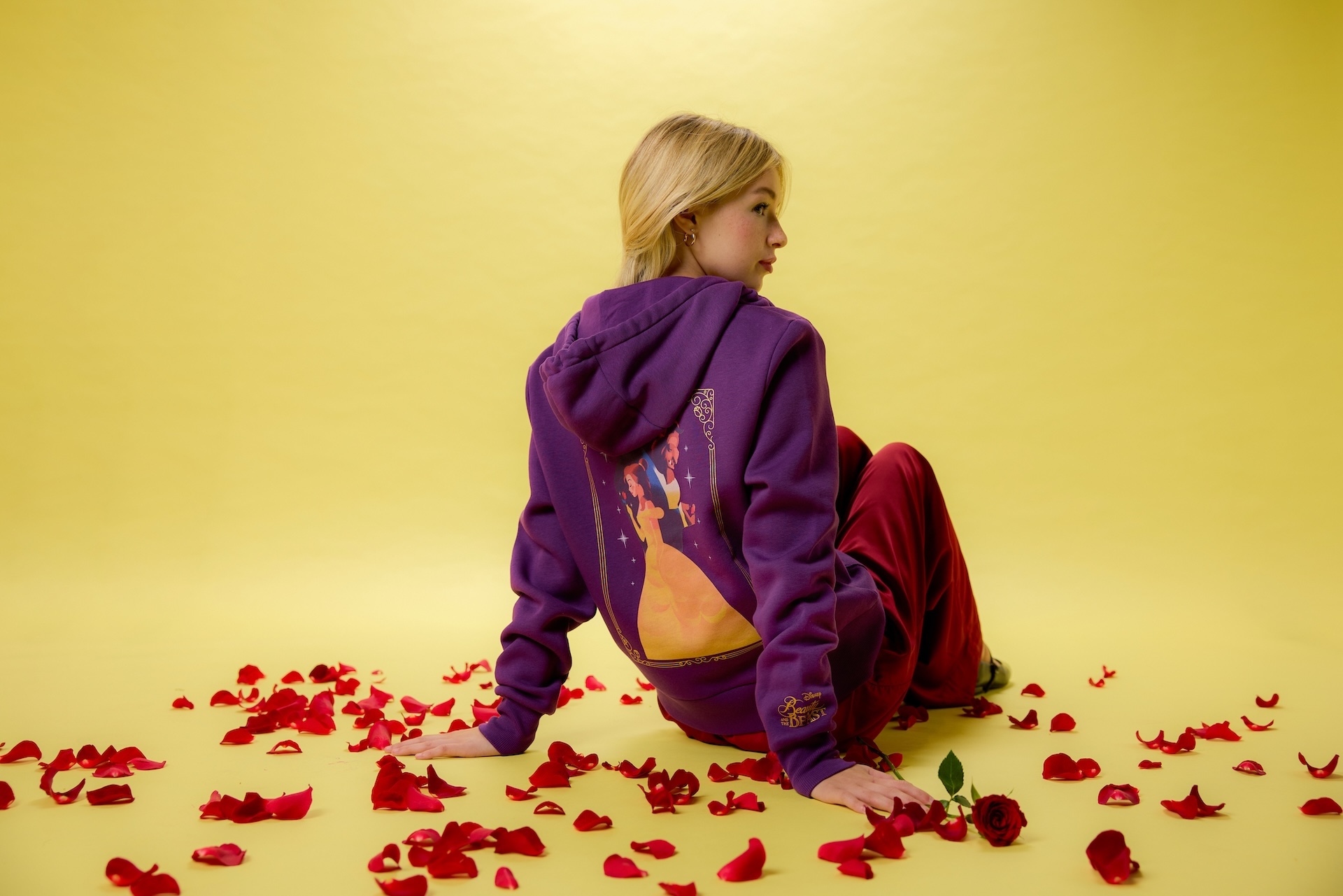 This rich purple Zip Hoodie for Women has lots of little details, like the shimmering film logo on the sleeve, embroidered rose on the front, and picturesque portrait of Belle and the bewitched prince on the back.