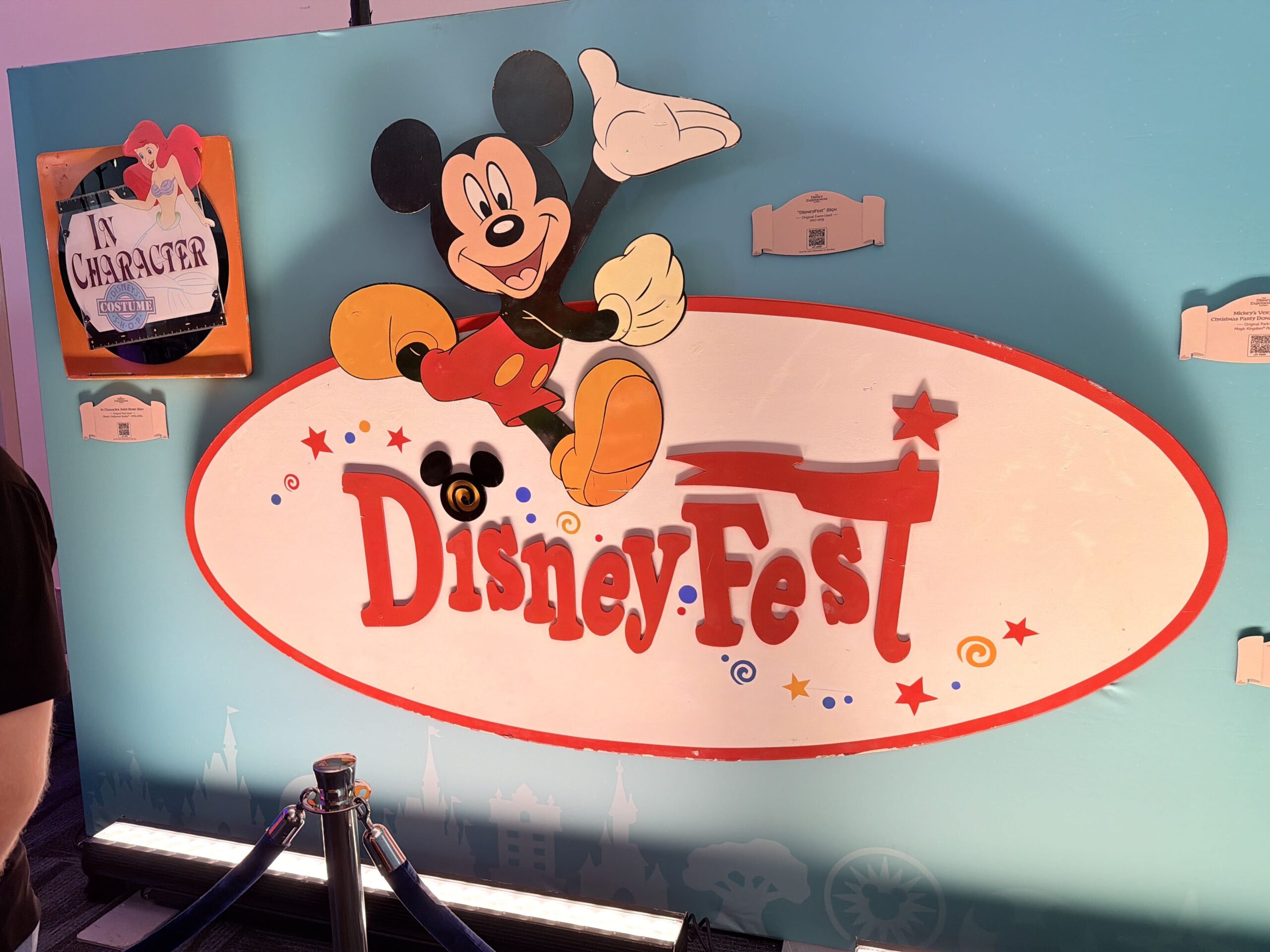 Signs and banners originate from Disney Fest, Mickey's Very Merry Christmas Party, Disney's Hollywood Studios, the Disneyland 50th celebration, Tomorrowland, and Spaceship Earth.