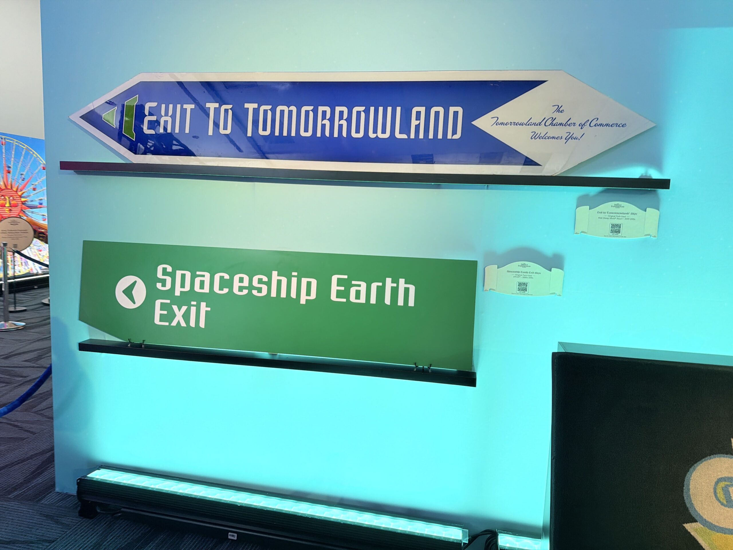 Signs and banners originate from Disney Fest, Mickey's Very Merry Christmas Party, Disney's Hollywood Studios, the Disneyland 50th celebration, Tomorrowland, and Spaceship Earth.