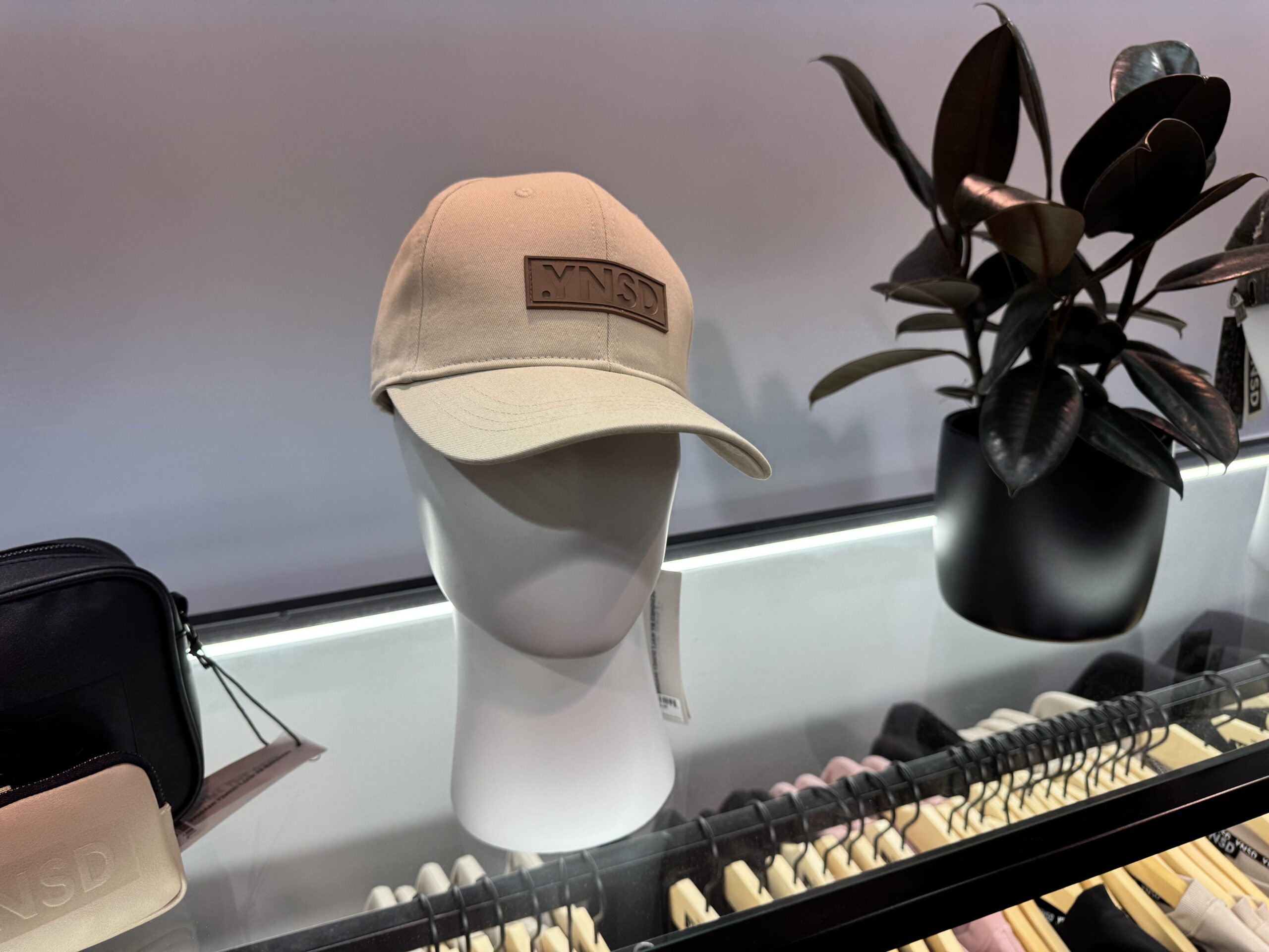 This cappuccino-colored baseball cap has the .YNSD logo patch on the front.
