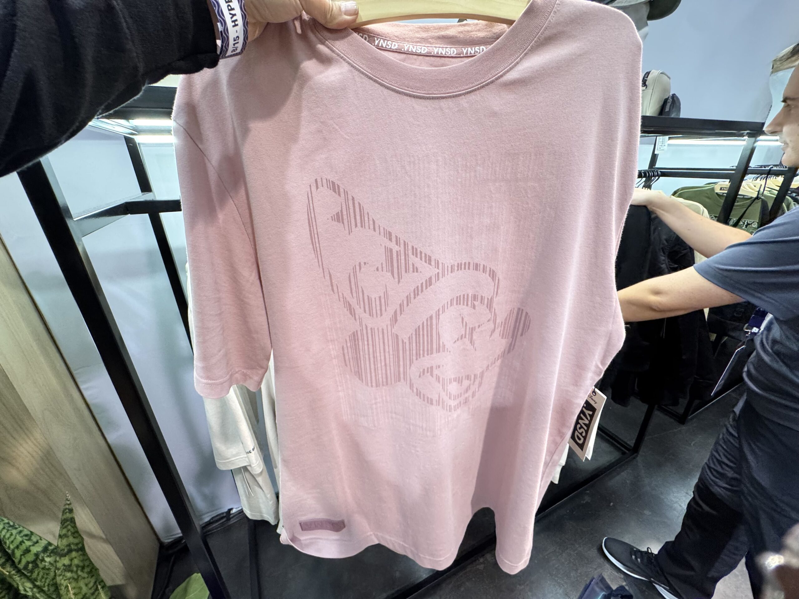 This UV-activated pink shirt has an image of Sorcerer Mickey on the front, and an image of Sorcerer Mickey and the logo on the back.