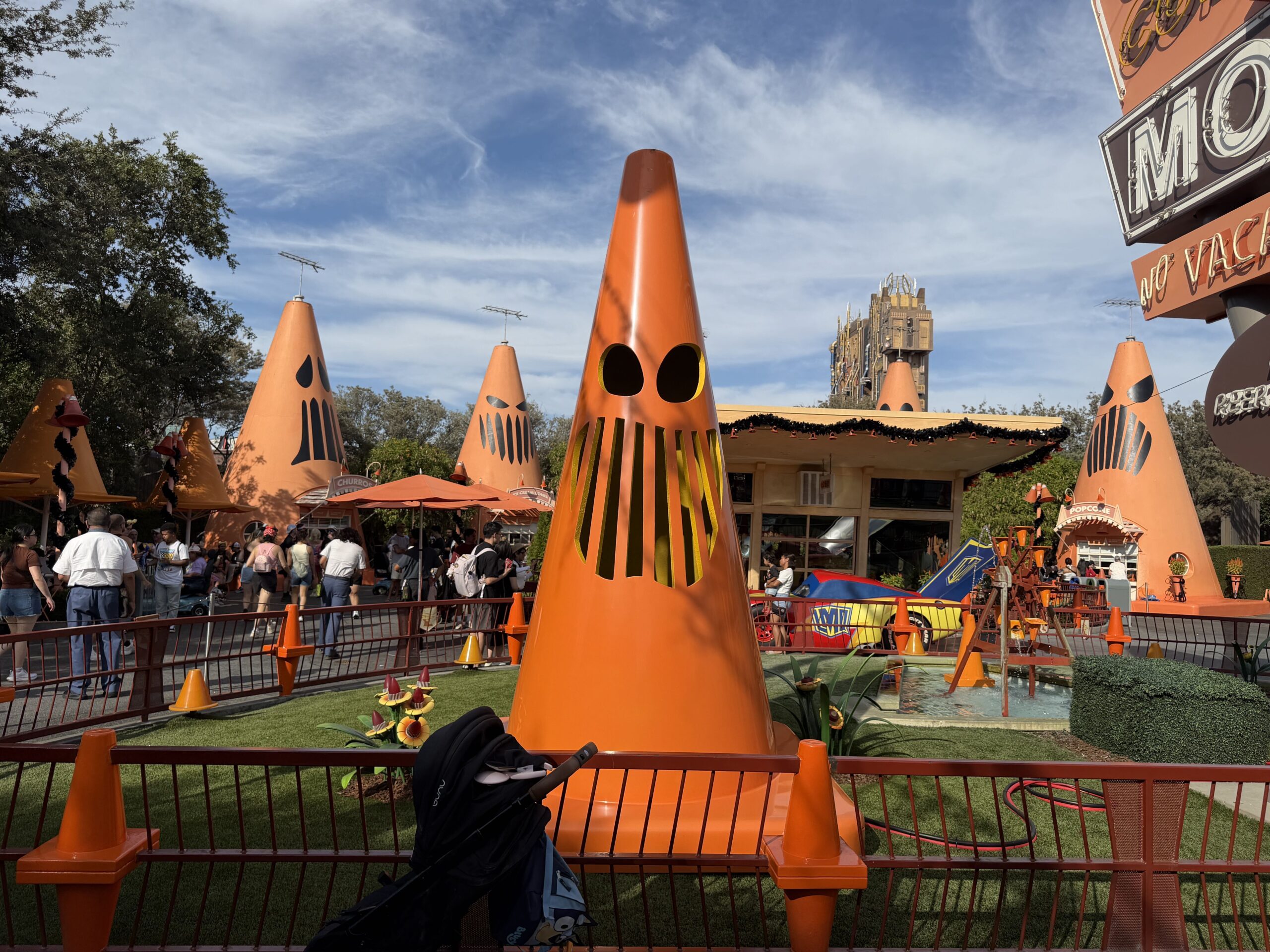 Giant Traffic cones with Jack-O'-lantern faces stand guarding around the perimeter of the Cozy Cone Motel, grimacing at guests for a fright.