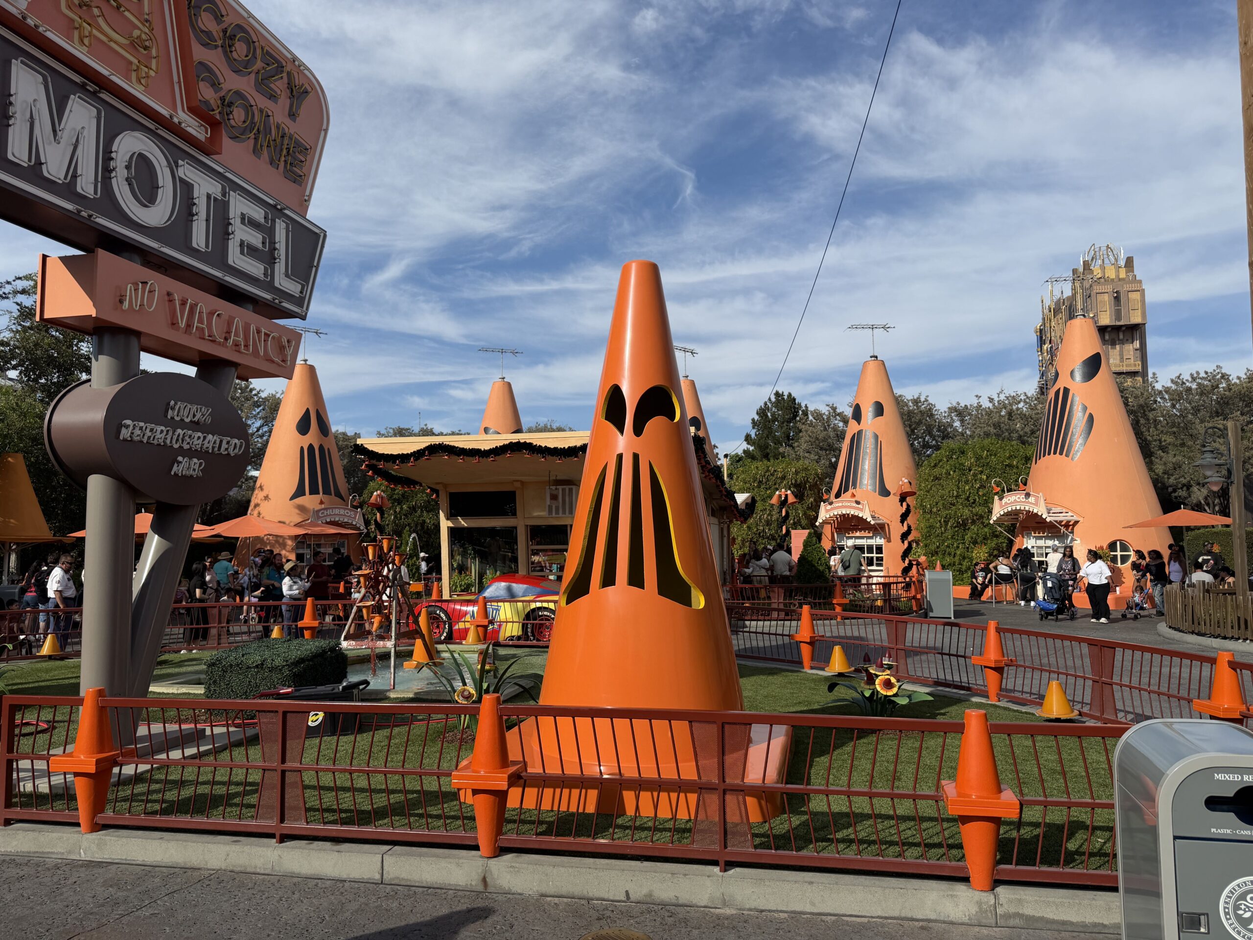 Giant Traffic cones with Jack-O'-lantern faces stand guarding around the perimeter of the Cozy Cone Motel, grimacing at guests for a fright.