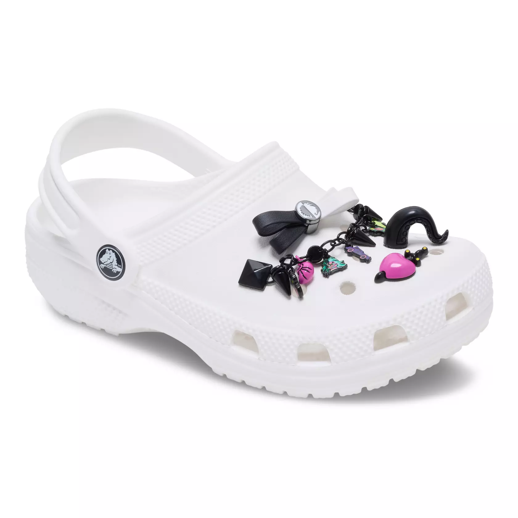 Decorate your Crocs with these four Jibbitz charms. A black chain with studs, spikes, and villain-themed charms attaches to two ventilation holes. The other charms are a black tentacle inspired by Ursula, heart and dagger based on the Evil Queen's box, and black and white bow inspired by Cruella.