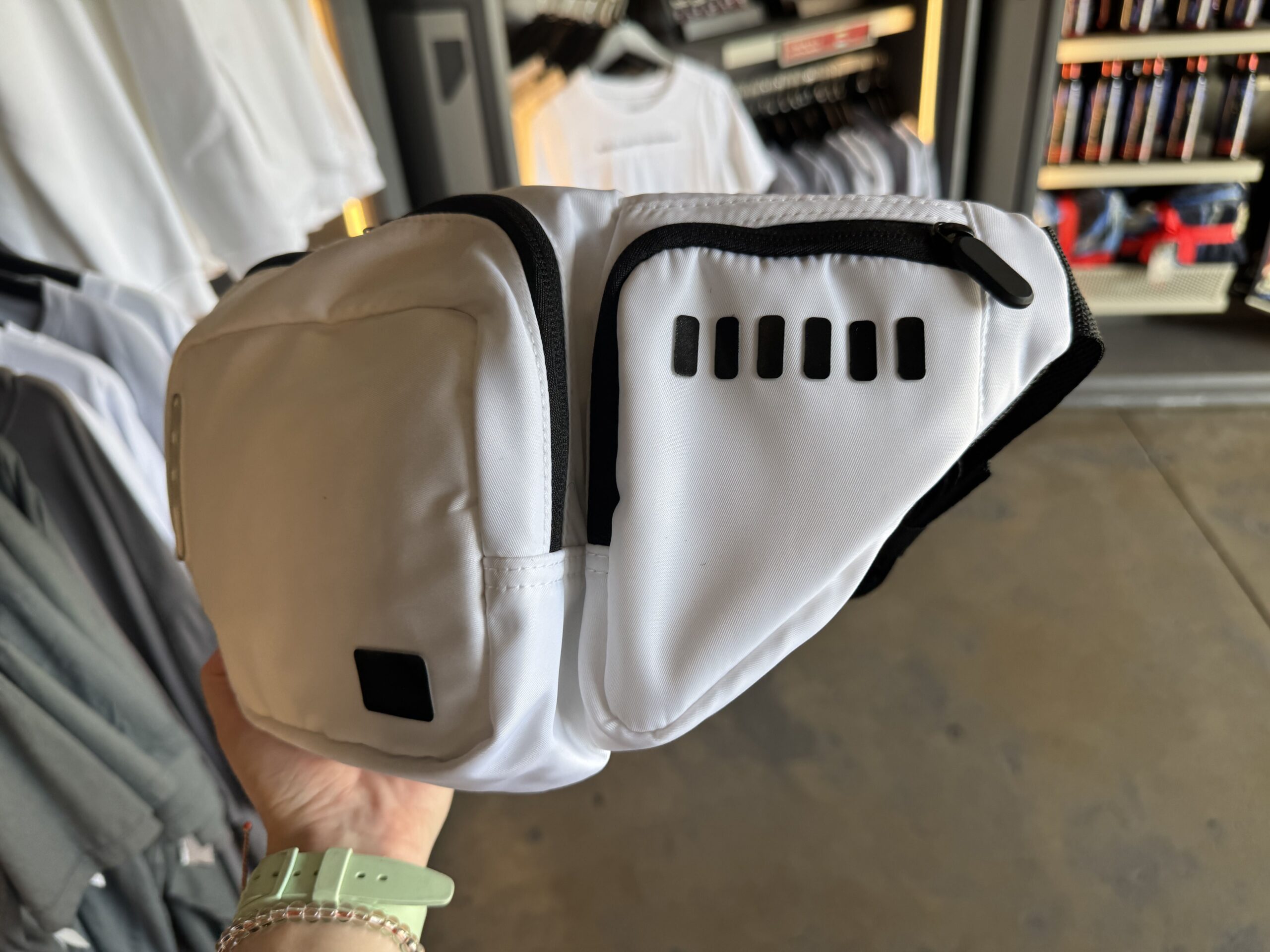 This belt bag emulates the look of a Stormtrooper and is made of white nylon with black stitching and zipper details. Black and white synthetic material decorates the front and side of the bag like the buttons and ventilation of Stormtrooper armor.