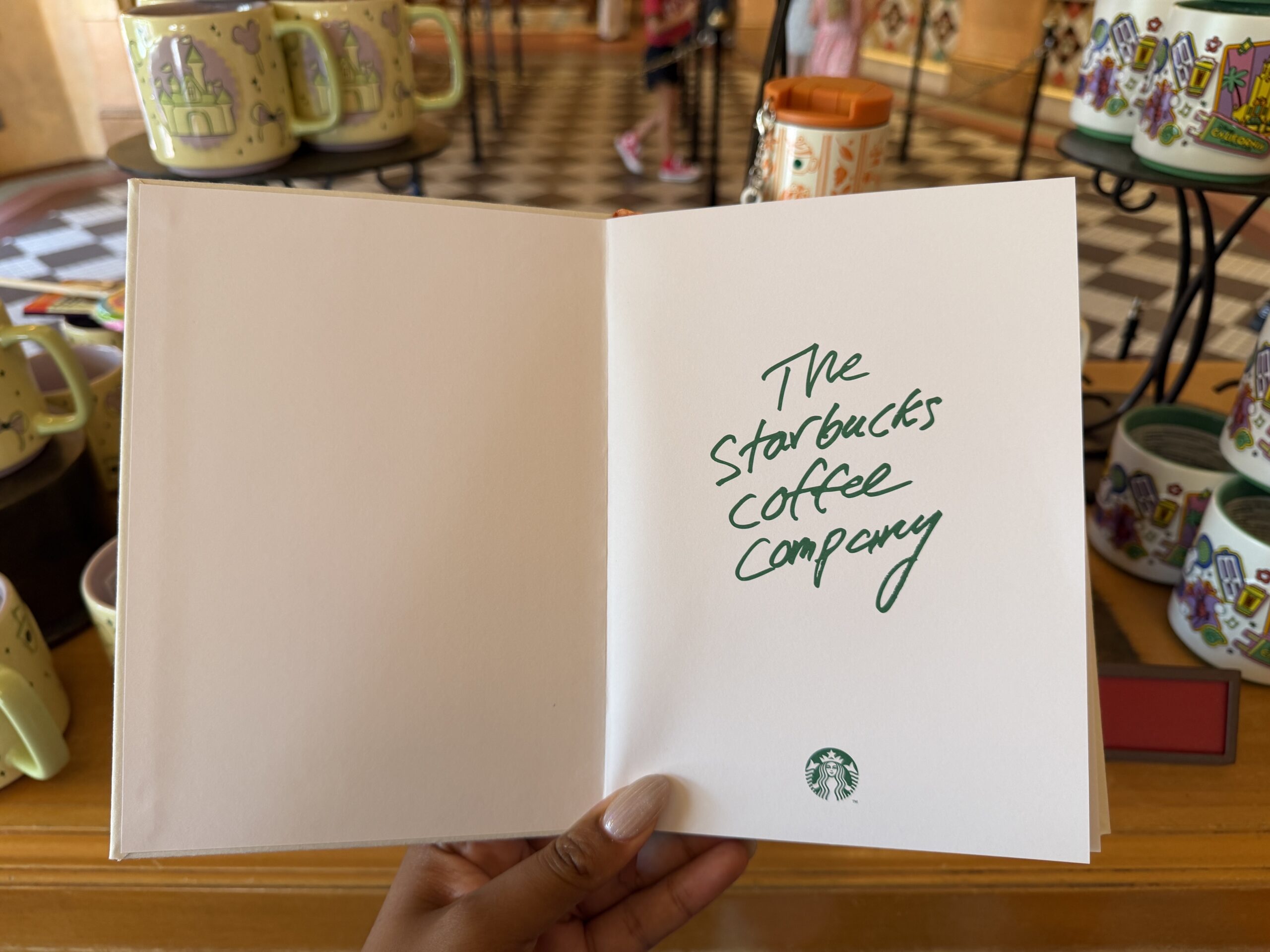 On the front page is "The Starbucks Coffee Company" in green. The rest of the pages are lined featuring latte and Minnie pumpkin icons in the corners.