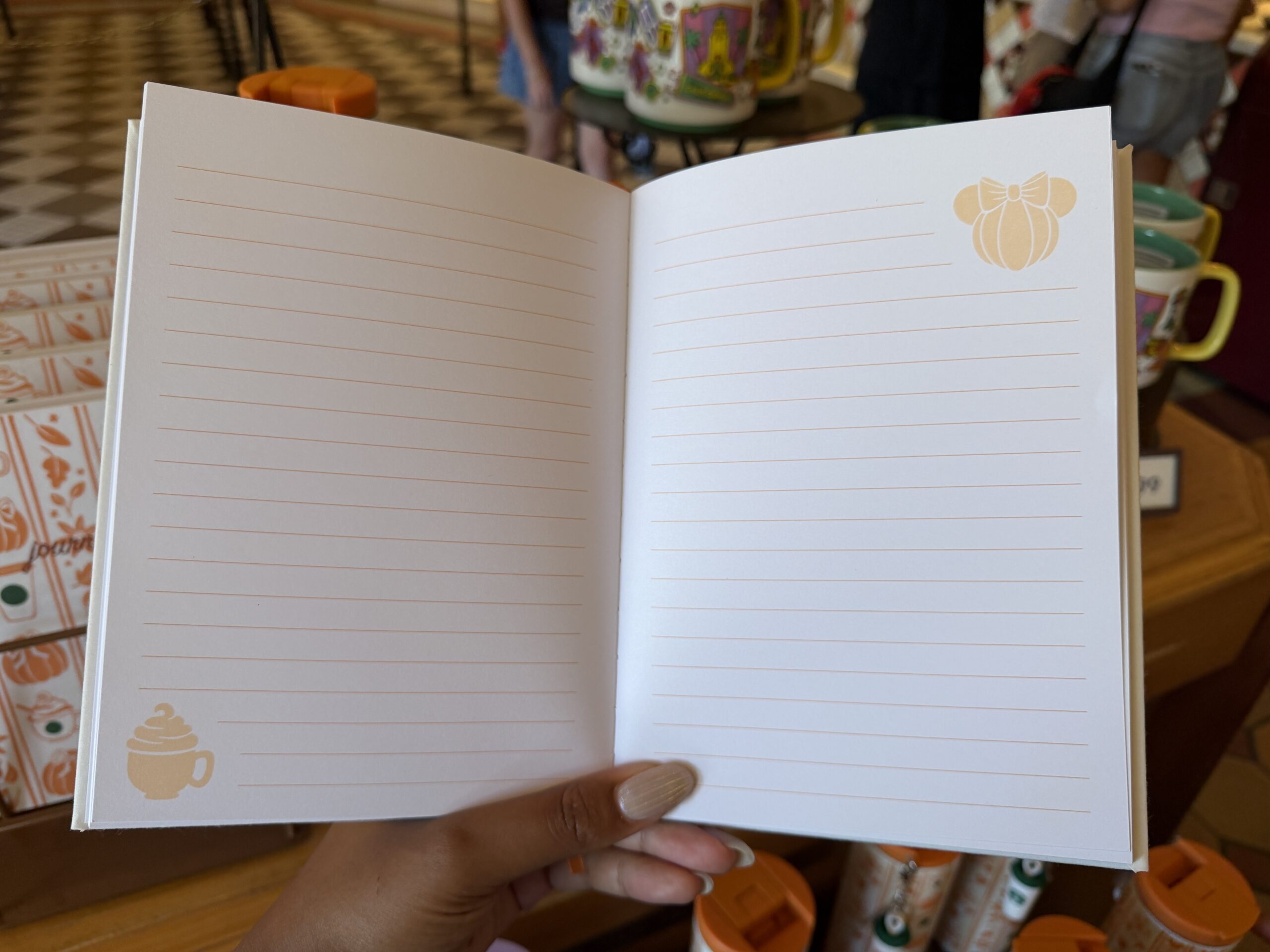 On the front page is "The Starbucks Coffee Company" in green. The rest of the pages are lined featuring latte and Minnie pumpkin icons in the corners.