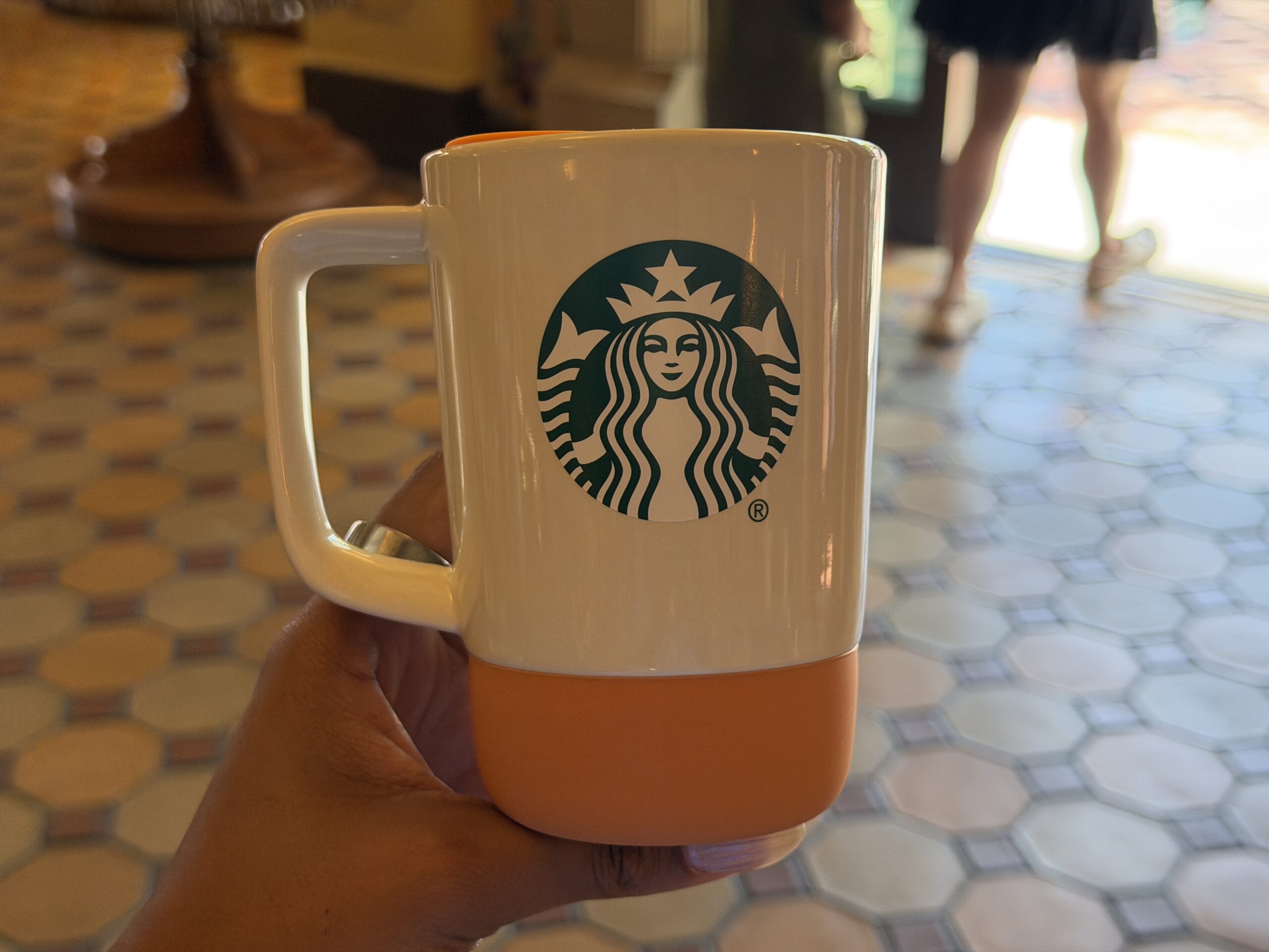 The Starbucks logo is in green on the other side. The lid has an opening for sipping or it can be removed.