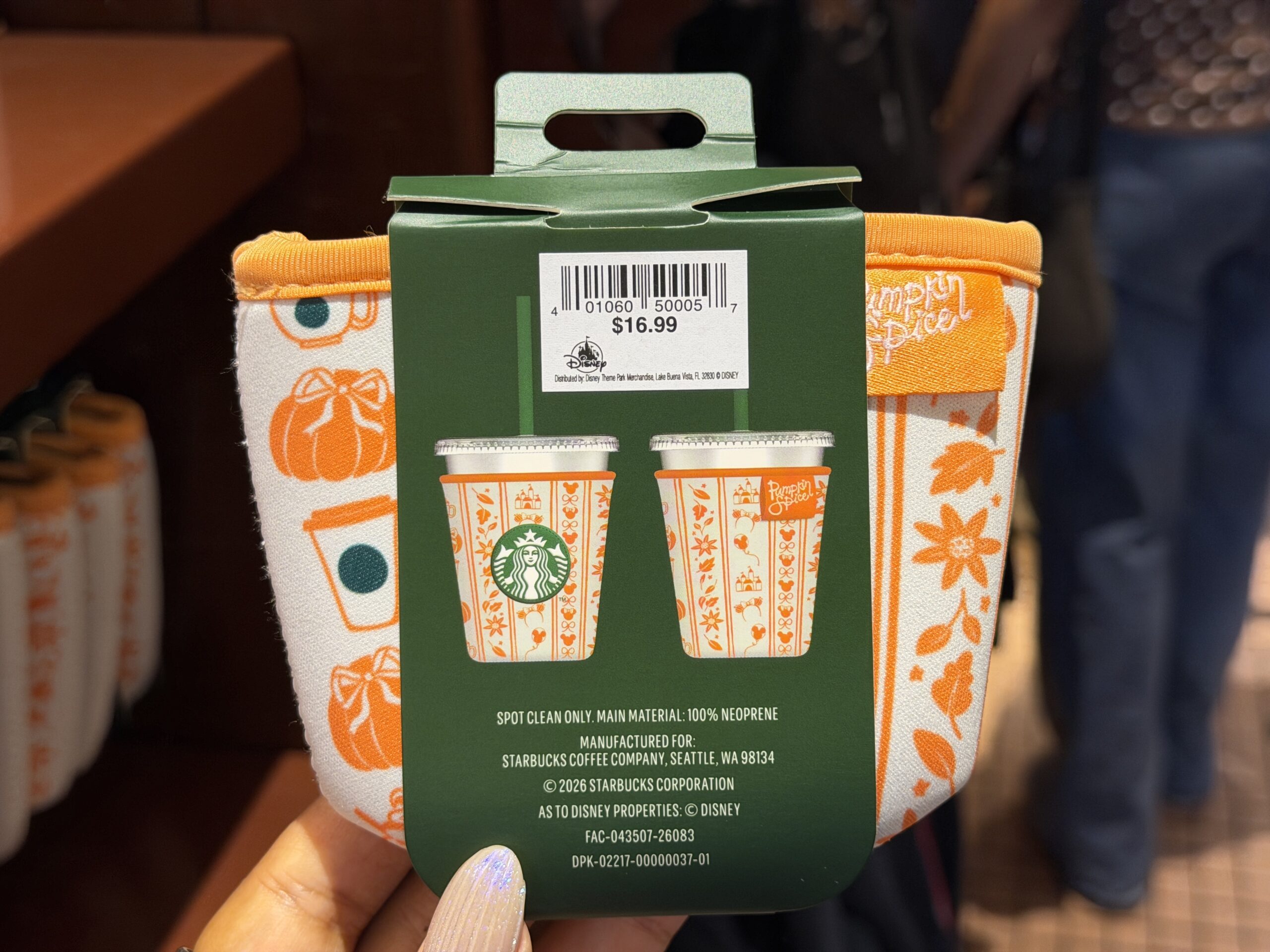 The cup sleeve features the same orange pattern as the bottle. The Starbucks logo is on one side. This size is compatible with Starbucks 16 oz cold cups.