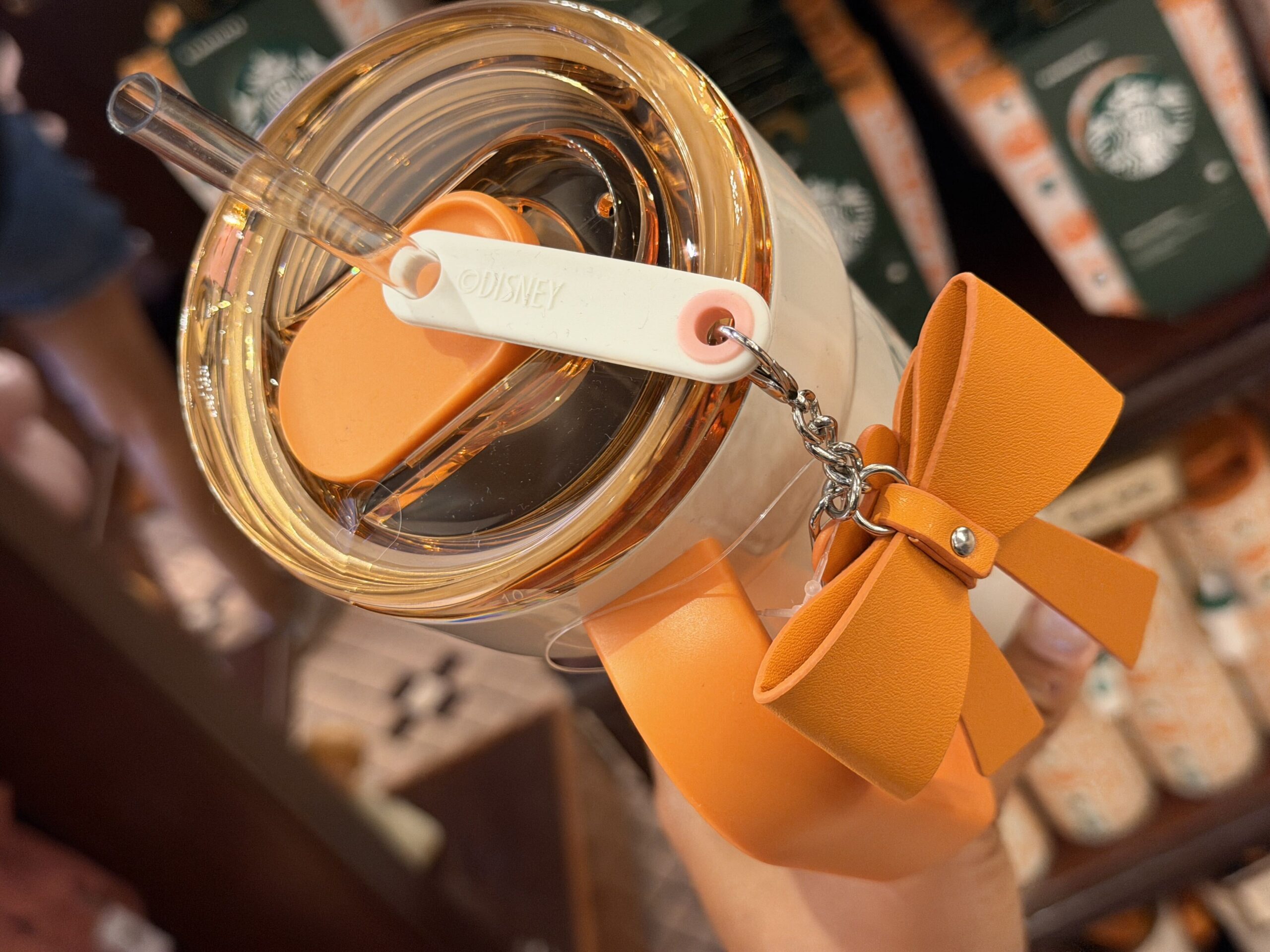 The charm hangs from a white piece on the lid. The cup is not microwave-safe or dishwasher-safe.