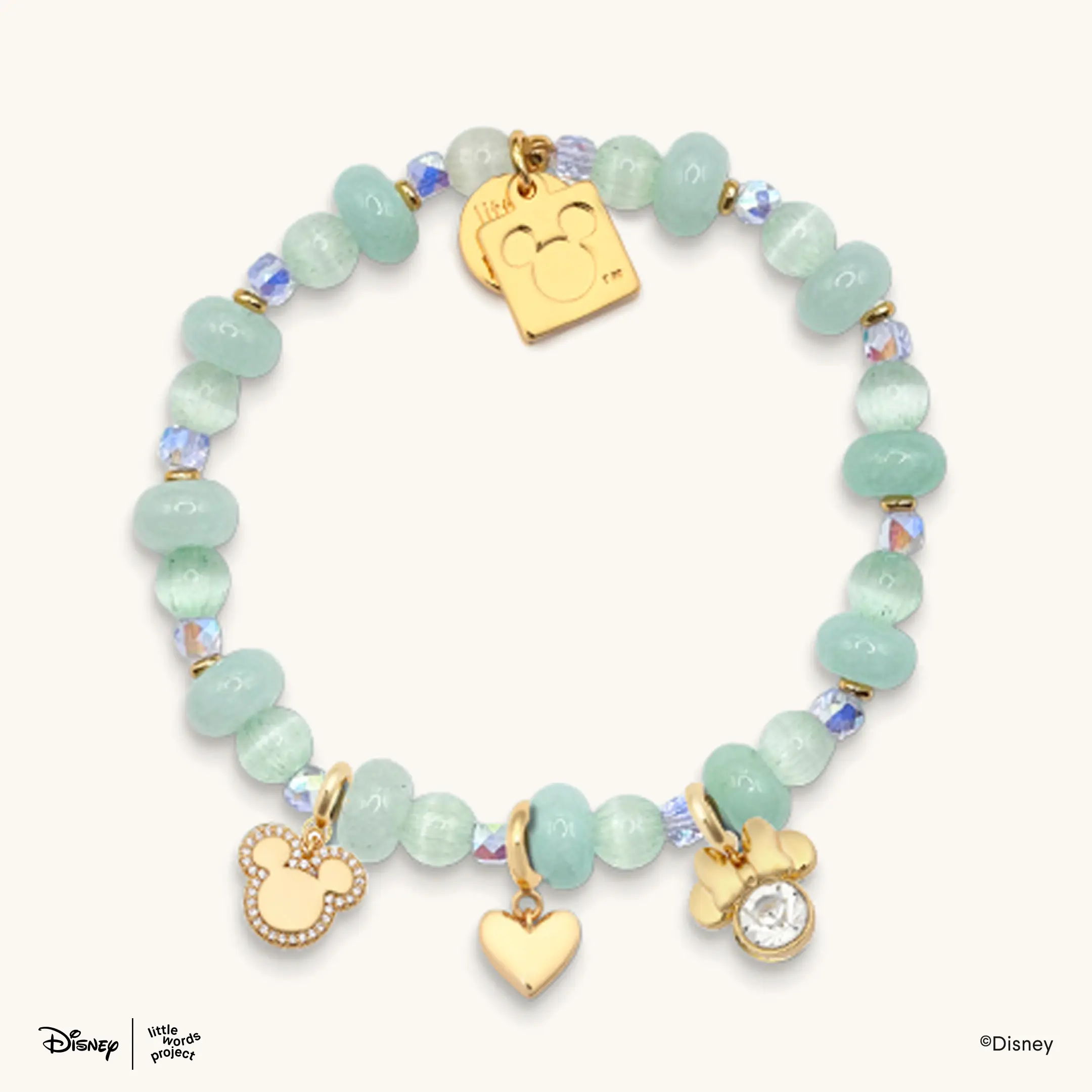 This bracelet has sea foam green-colored beads in various shapes and sizes. It also comes with three dangling gold charms: A Mickey head with a bedazzled outline, a heart, and a Minnie head with a clear gem in the center of the head.