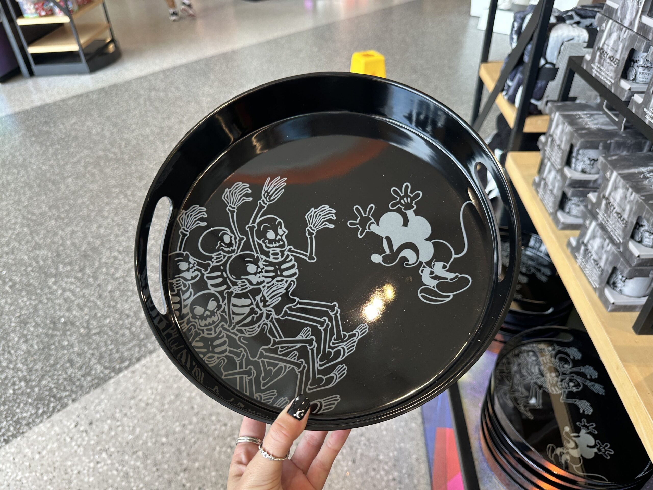 Mickey being scared by the skeletons is depicted on this black tray. Mickey and the skeletons are white outlines.