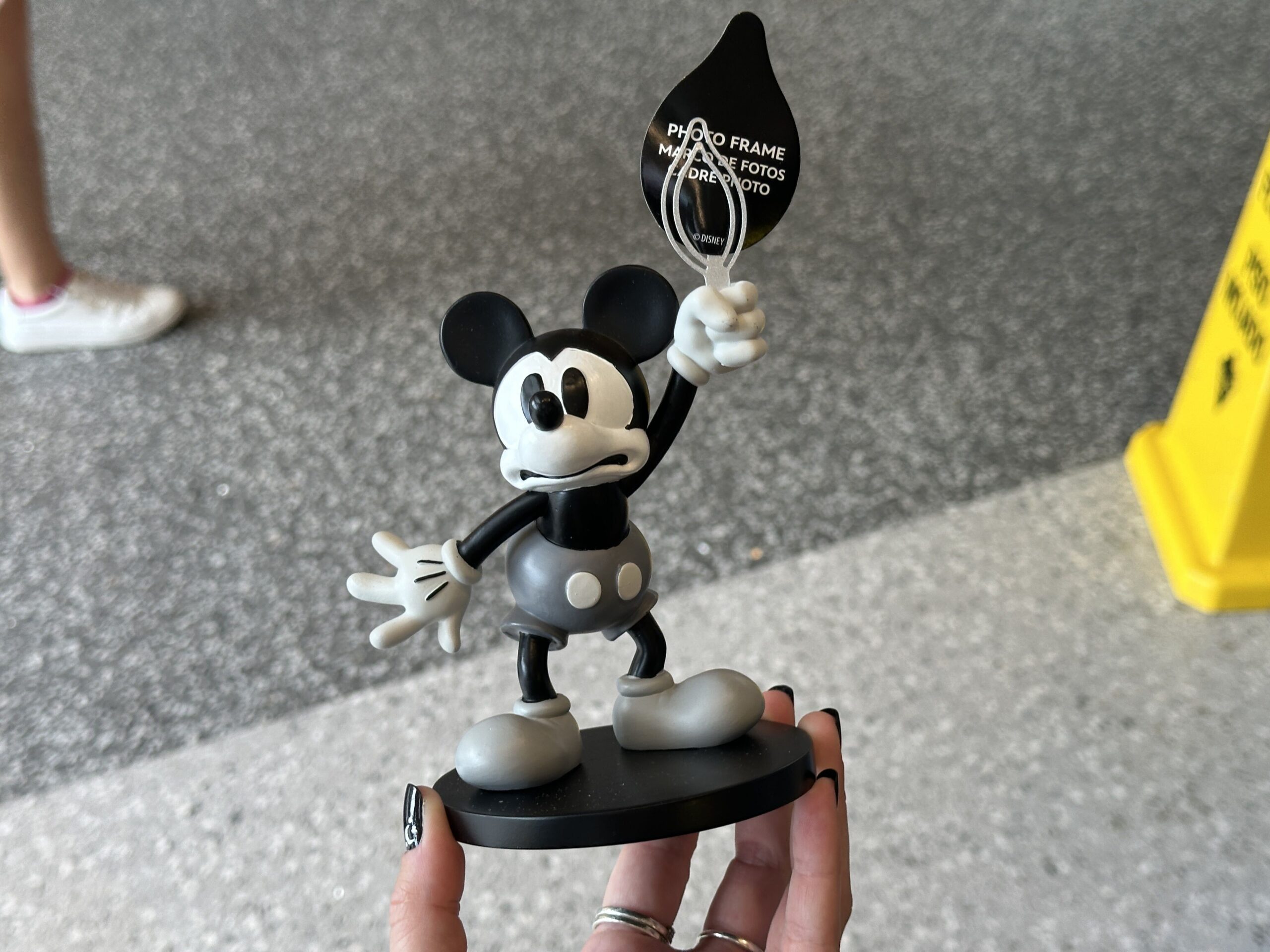 A frightened, grayscale Mickey Mouse is shown in this figural photo holder. He is holding up a candle and the flame outline is what holds your picture in place.