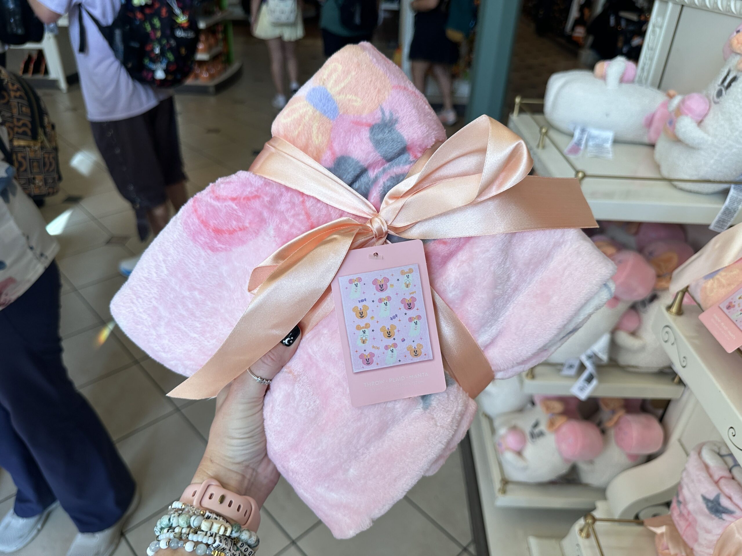The pink throw blanket features Mickey and Minnie ghosts, as well as Mickey and Minnie jack-o'-lanterns.
