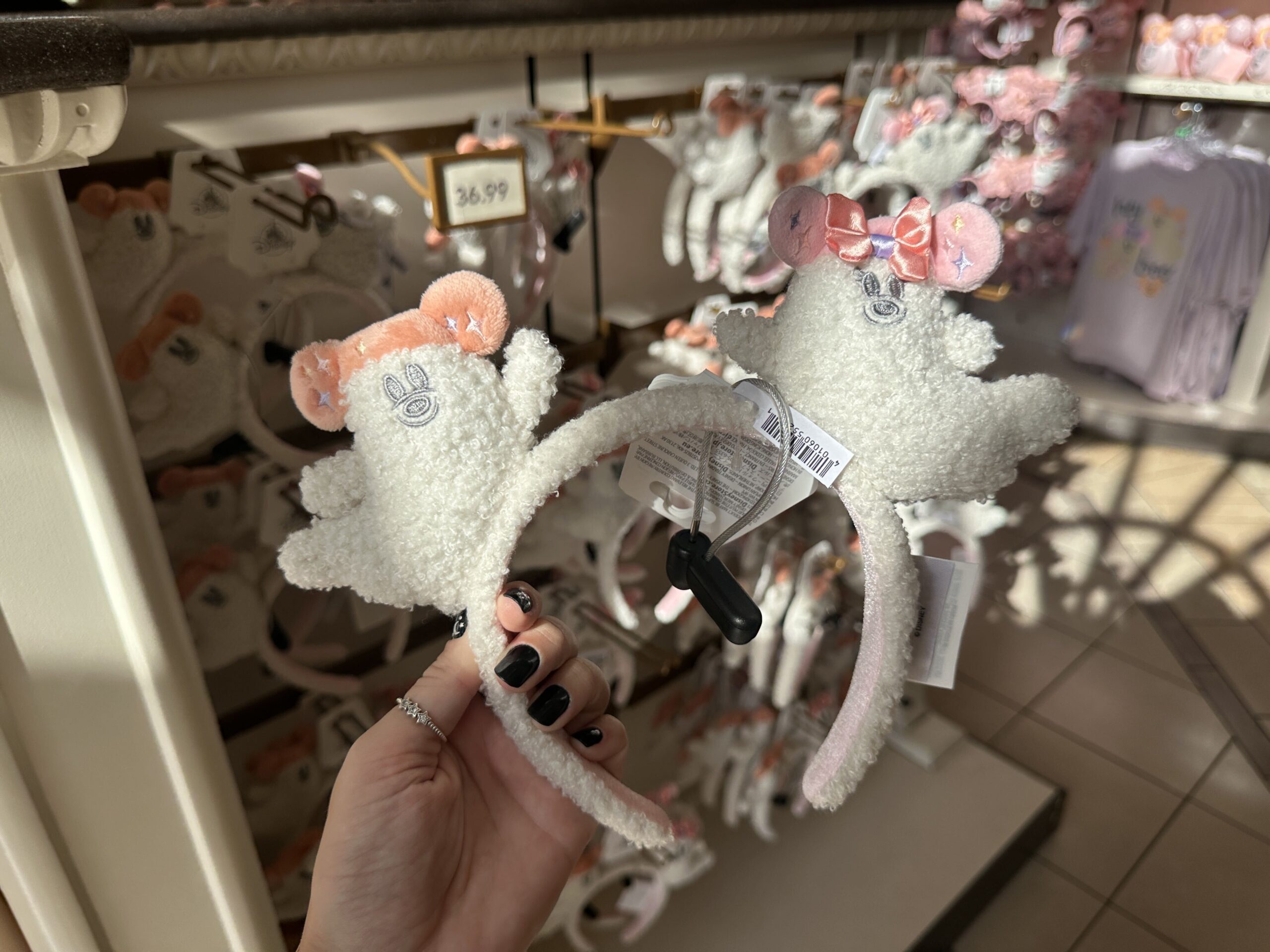 The fuzzy ear headband features a Mickey ghost on one ear and a Minnie ghost on the other.