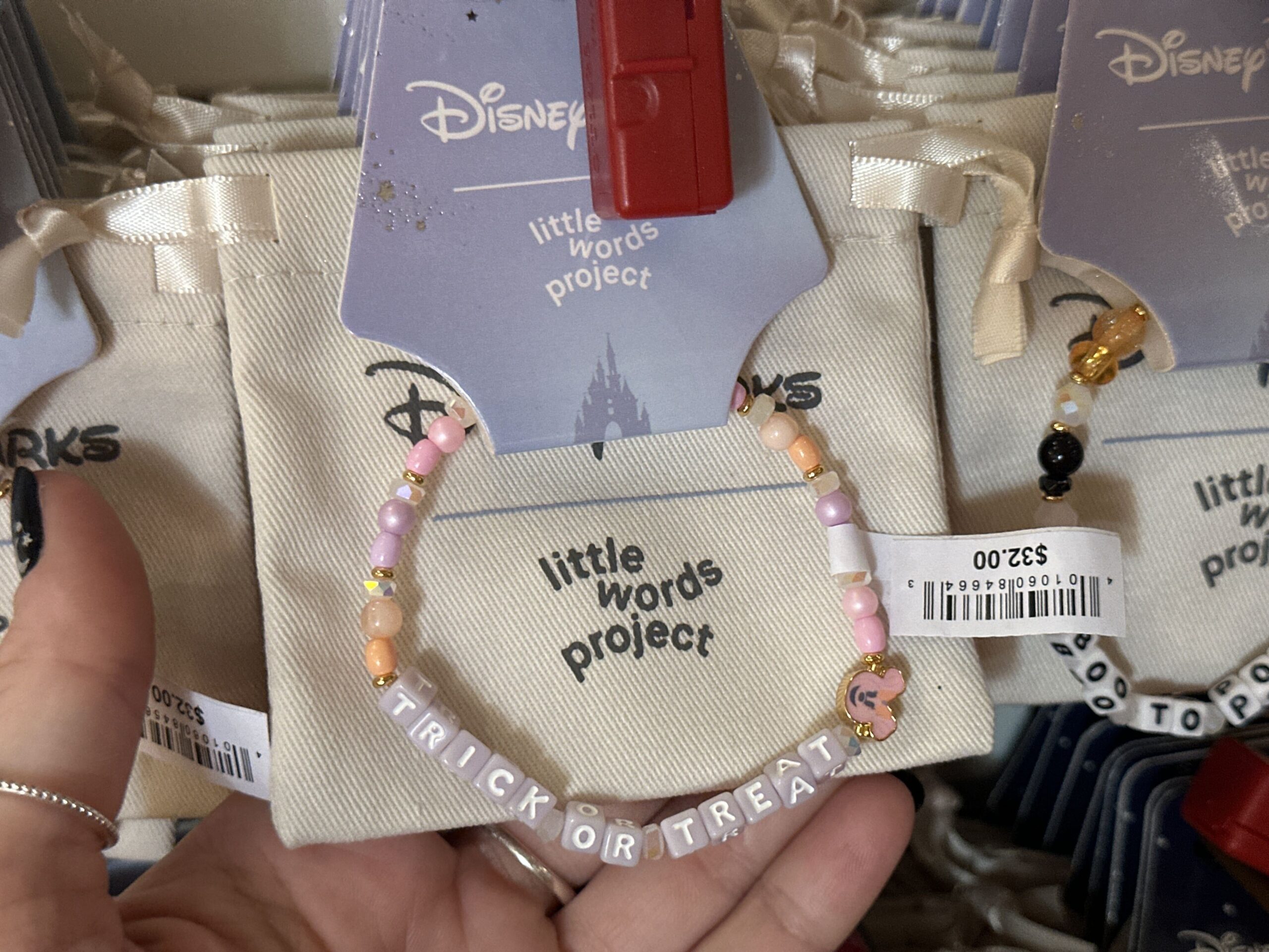 "Trick or Treat" is spelled out in purple letter beads. A Minnie jack-o'-lantern charm is on the end, and pink, purple, and orange accent beads cover the rest of the bracelet.