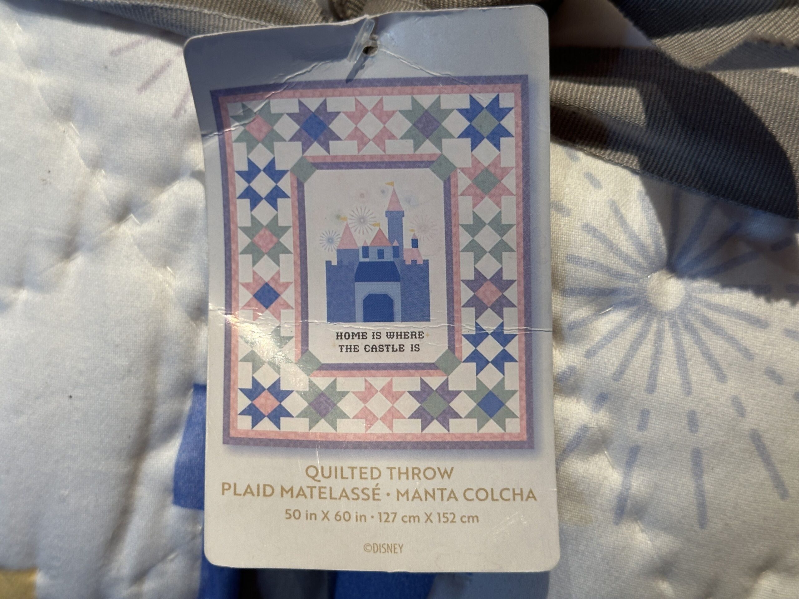 Beneath the castle reads "Home is where the castle is" stitched into the fabric. It measures 50 in x 60 in in size.