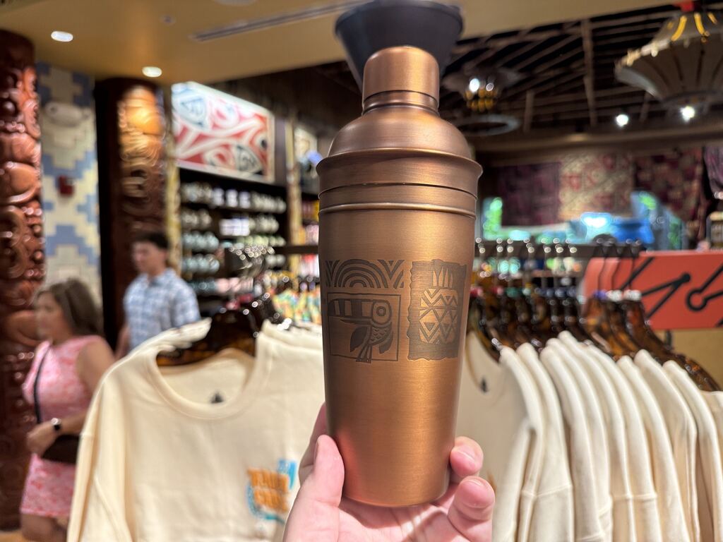 All around the cup are engraved designs that match the tropical aesthetic of the bar, including a tucan and other tiki-related designs.