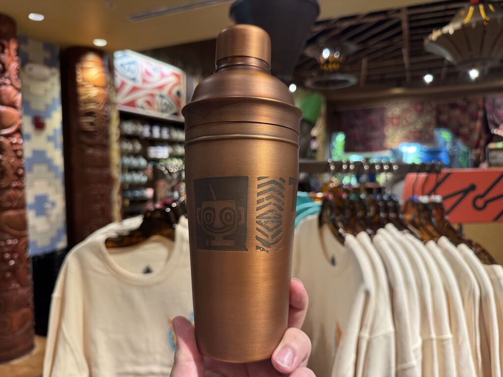 All around the cup are engraved designs that match the tropical aesthetic of the bar, including a tucan and other tiki-related designs.