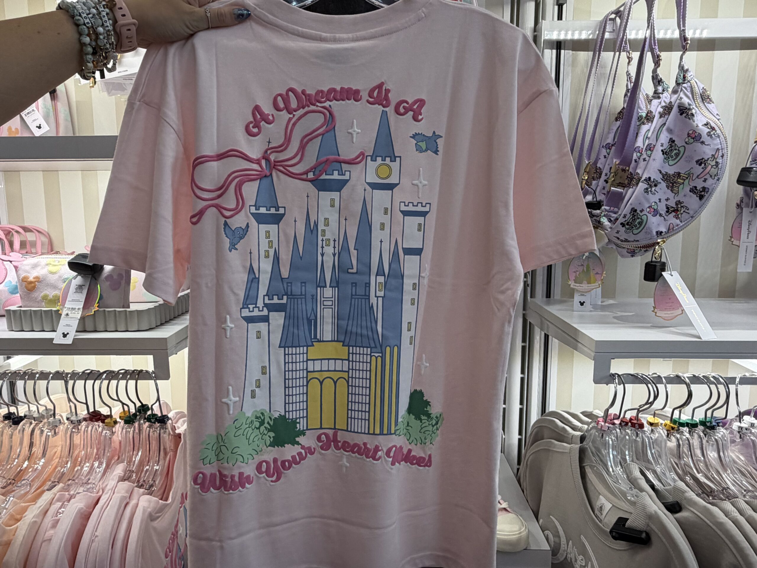 Three new Disney tops by Skinnydip London have arrived at Disney Ever After in Disney Springs, featuring pastel colors, Cinderella Castle, and phrases inspired by Disney dreams.