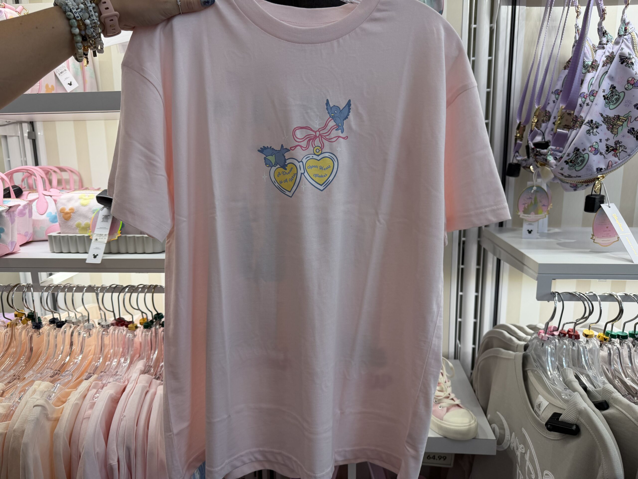 Three new Disney tops by Skinnydip London have arrived at Disney Ever After in Disney Springs, featuring pastel colors, Cinderella Castle, and phrases inspired by Disney dreams.