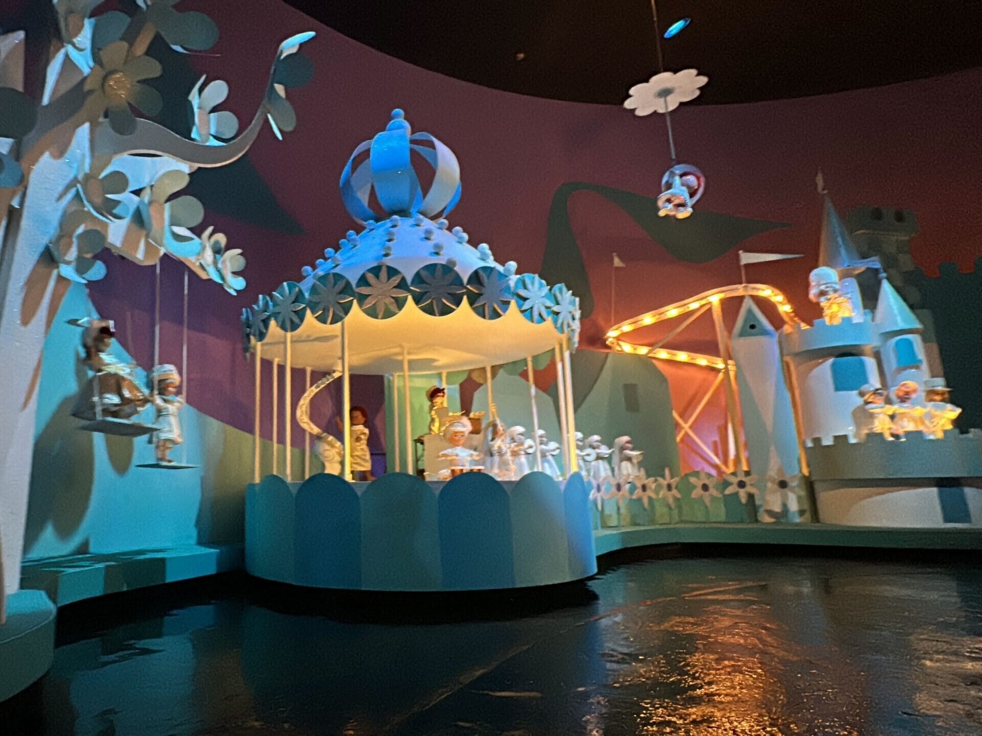 Colorful carousel with dolls in blue and white costumes captures the magic of Magic Kingdom’s it’s a small world ride.