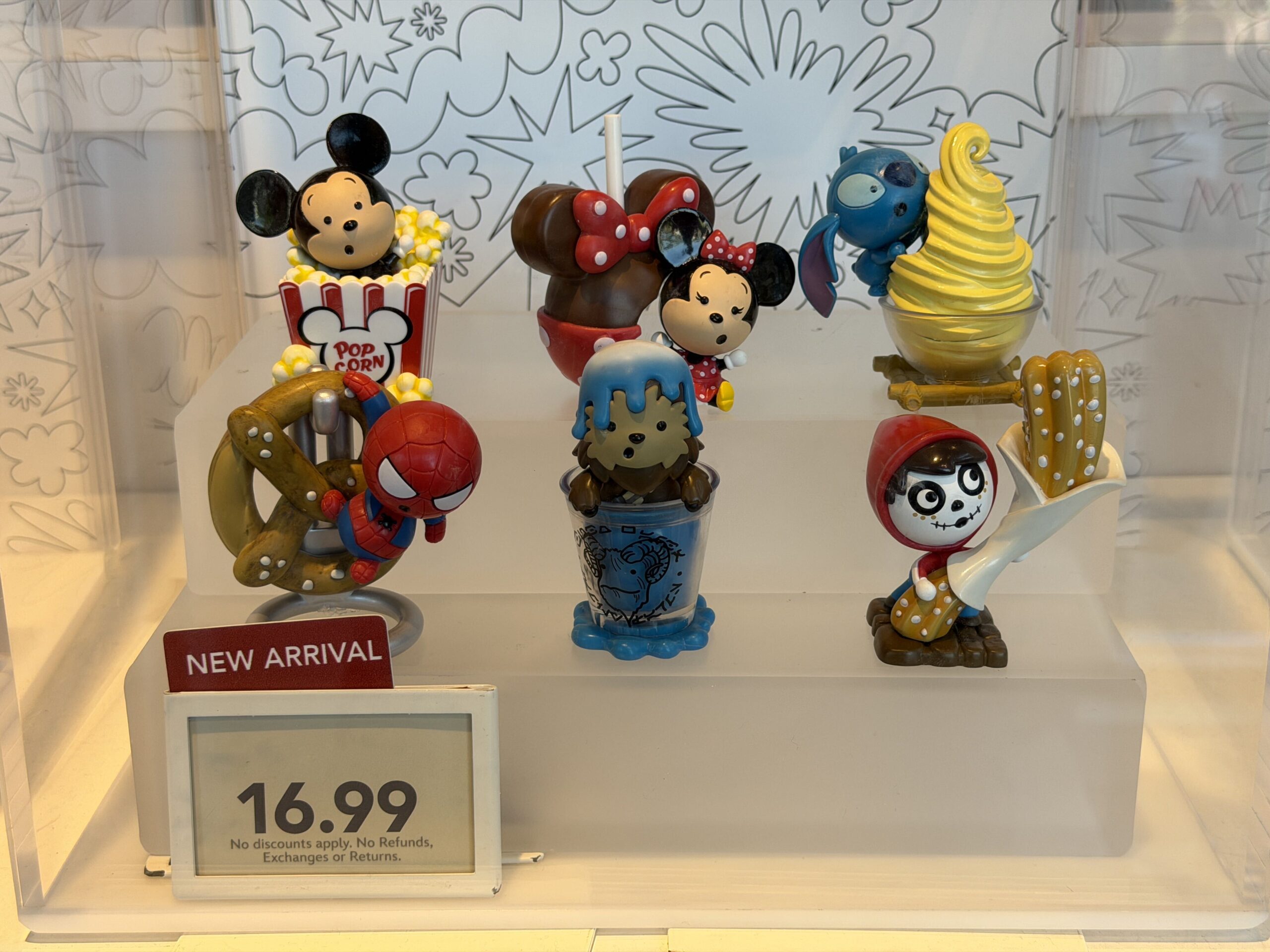 This Mystery Box Set contains six figurines of miniature Disney characters, each paired with a giant version of a snack from the Disney Parks. Mickey Mouse is paired with a box of popcorn, Minnie Mouse is paired with a caramel apple themed to her signature bow-and-polka dot look, Stitch is licking a Dole Whip, Spider-Man hangs from a Pym's soft pretzel, Chewbacca pops up from inside of a cup of Blue Milk, and Miguel holds a cinnamon-dusted churro. 
The characters are animated in a "cutsie," "chou-chou" style.
